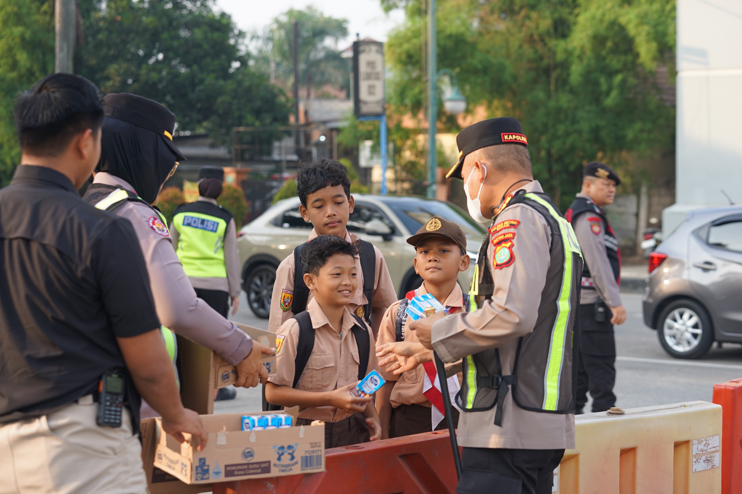 Kapolres Metro Bekasi Pimpin Yanmas Pagi, Bantu Penyeberangan Dan Bagikan Susu ke Pelajar di Jurong